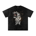 A black acid-wash graphic t-shirt featuring a roaring tiger wearing a gold chain necklace with the word 'MADNESS' in a dripping font below it, displayed flat against a white background.