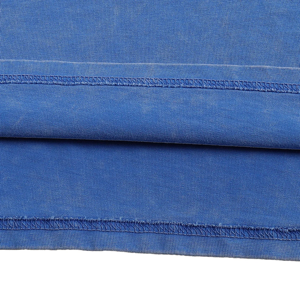 Close-up of blue fabric with a visible seam on a white background