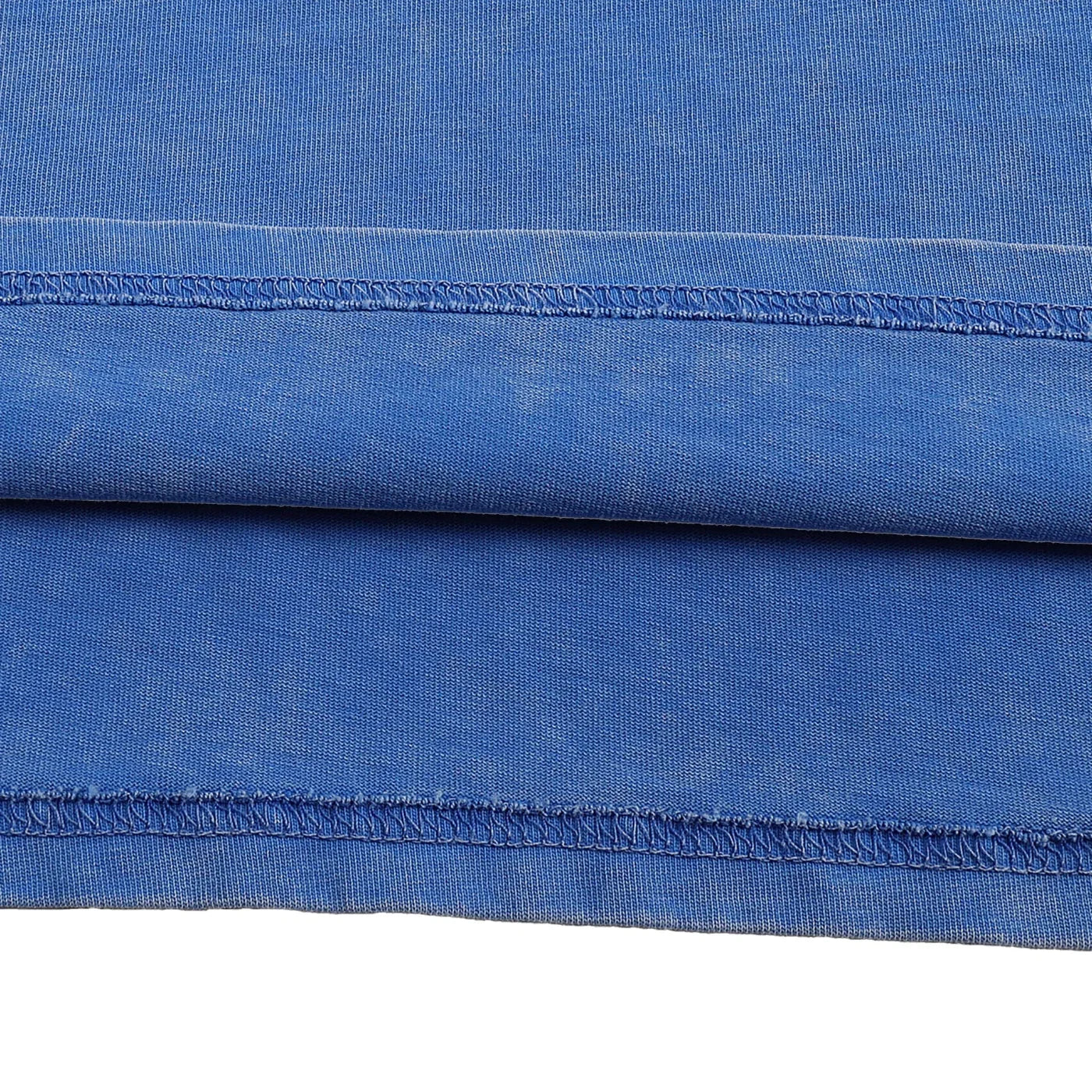 Close-up of blue fabric with a visible seam on a white background