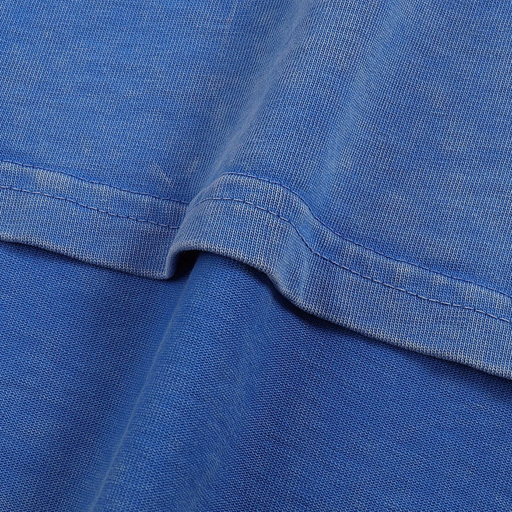 Close-up of blue fabric with a focus on texture and stitching.