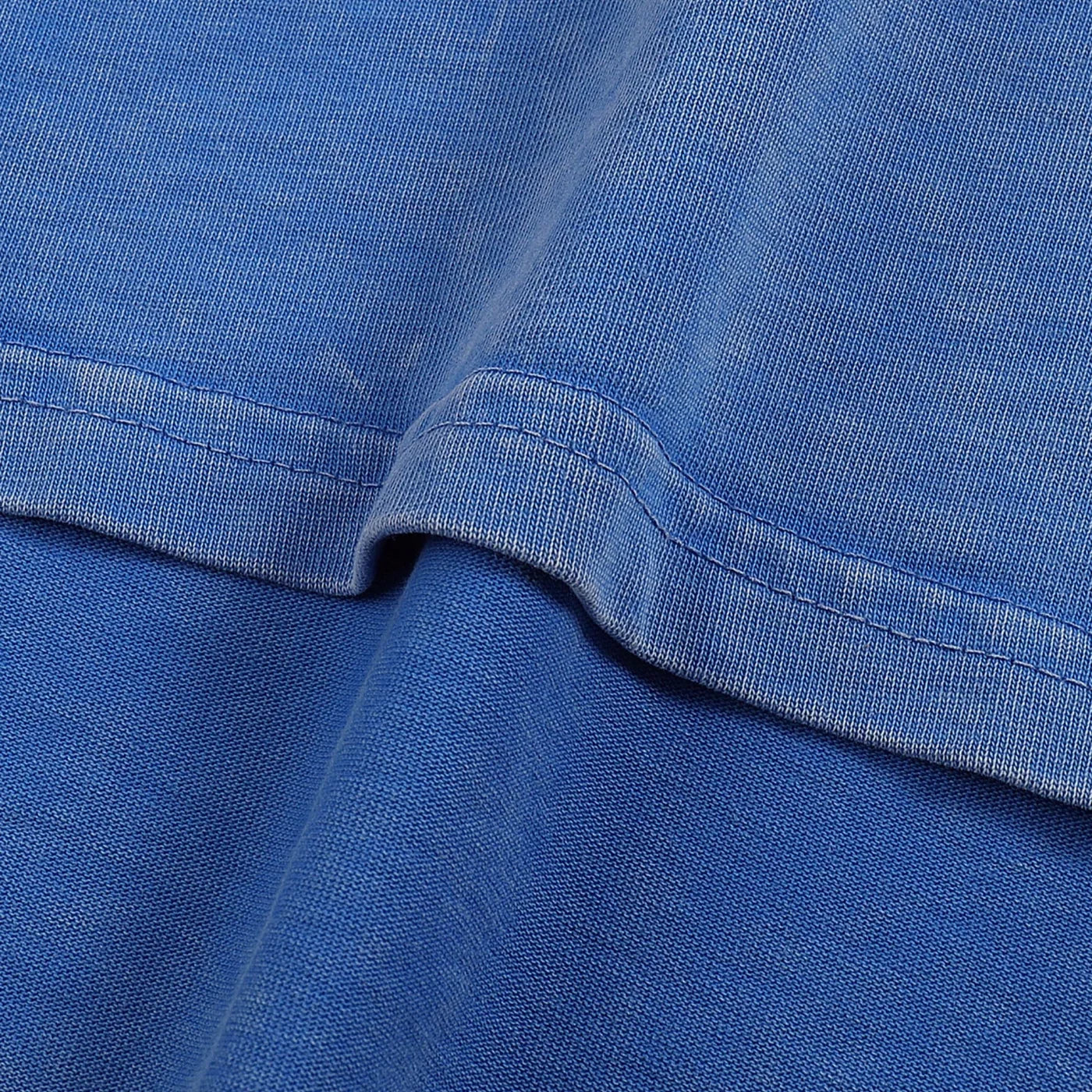 Close-up of blue fabric with a focus on texture and stitching.